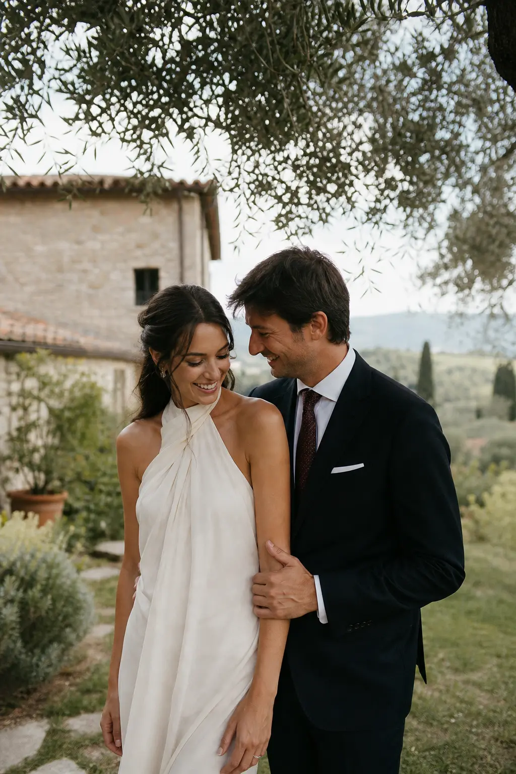 A fictional engaged couple sharing a quiet laugh in an olive grove